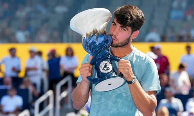 Carlos Alcaraz kisses the trophy after winning the Cincinnati Open crown, celebrating his tennis championship victory.