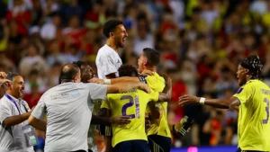 Para pemain dan staf Al-Nassr merayakan dengan penuh semangat usai kemenangan 2–1 atas Al-Ittihad pada semifinal Saudi Super Cup, dengan para rekan setim saling berpelukan di lapangan.