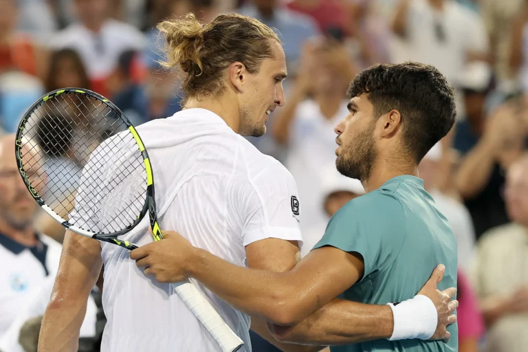 Alexander Zverev and Carlos Alcaraz share a handshake and embrace at the net after their match, showing sportsmanship during the Cincinnati Open.