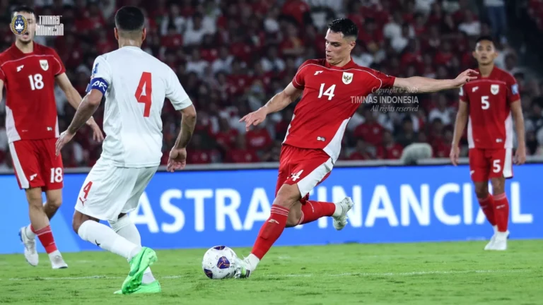 Joey Pelupessy menendang bola melawan pemain lawan nomor 4, dengan latar stadion penuh suporter.