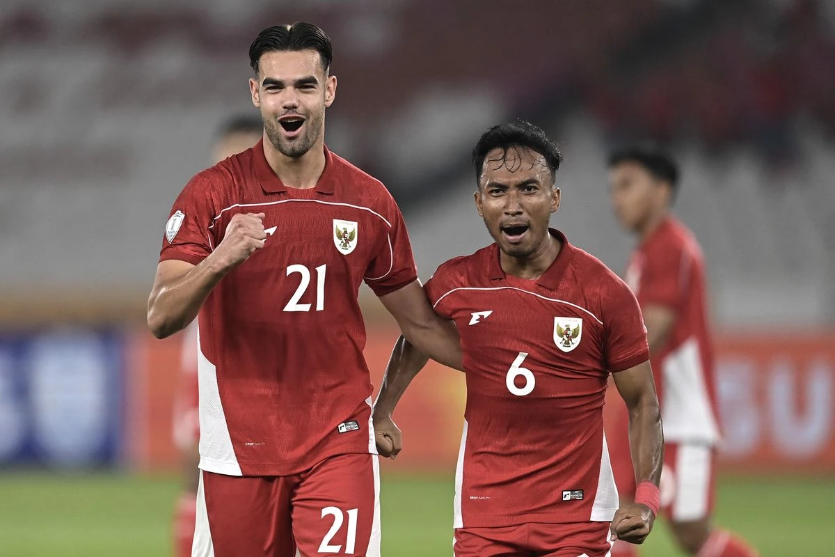 Pemain Timnas Indonesia merayakan kemenangan bersama rekan setim dengan kostum merah, diiringi sorakan suporter di stadion.